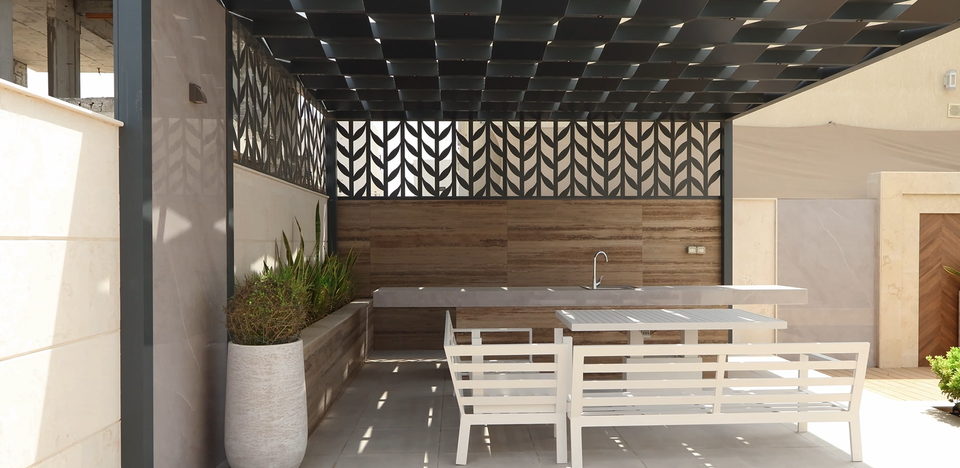 A patterned pergola over an outdoor dining terrace with planters, project A20